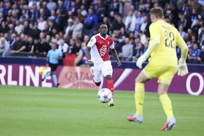 Folarin Balogun (izquierda) de Mónaco se perfile frente al arquero Simon Mignolet de Club Brujas en el partido de la Liga de Campeones, el jueves 18 de septiembre de 2025, en Brujas. (AP Foto/Omar Havana)