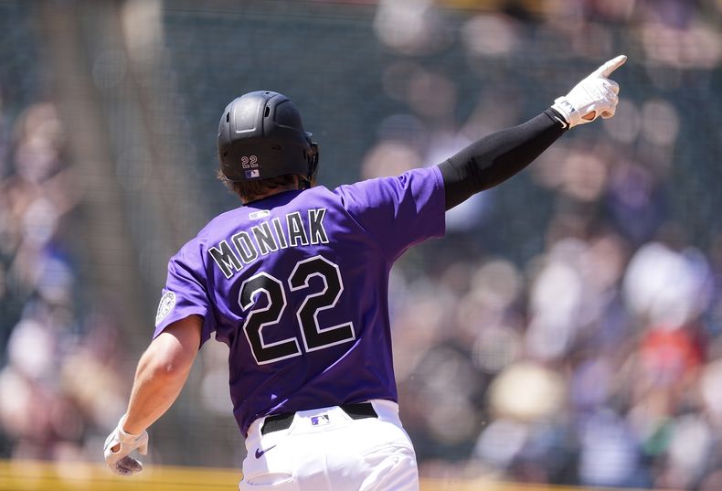Mickey Moniak, de los Rockies de Colorado, apunta hacia las gradas mientras recorre las bases después de batear un cuadrangular de tres carreras frente al abridor de los Diamondbacks de Arizona, Brandon Pfaadt, en la quinta entrada del juego de béisbol de Grandes Ligas, el domingo 22 de junio de 2025, en Denver. (AP Foto/David Zalubowski)