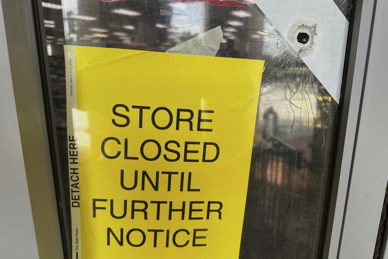Vista de la puerta de una farmacia CVS perforada por una bala el sábado 9 de agosto de 2025, cerca de donde un hombre disparó el viernes en la sede de los Centros para el Control y la Prevención de Enfermedades (CDC), en Atlanta, dejando un oficial muerto. (AP Foto/Jeff Amy)