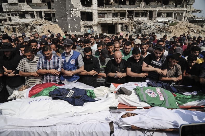 Palestinos rezan junto a cadáveres de periodistas, incluidos los corresponsales de Al Jazeera Anas al-Sharif y Mohamed Qreiqeh, que murieron en un ataque aéreo israelí, durante su funeral en las afueras del complejo hospitalario Shifa de la ciudad de Gaza, el lunes 11 de agosto de 2025. (Foto AP/Jehad Alshrafi)