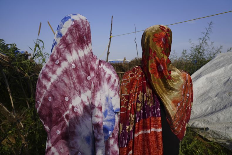 Mujeres que huyeron de la guerra en Sudán y pidieron hablar bajo condición de anonimato por temor a represalias tras denunciar explotación sexual, caminan por un campo de refugiados en Adre, Chad, el 5 de octubre de 2024. (AP Foto/Sam Mednick)