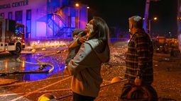 Personas observan cómo socorristas trabajan para extinguir un incendio tras un ataque ruso en Kiev, Ucrania, el martes 25 de noviembre de 2025. (AP Foto/Dan Bashakov)