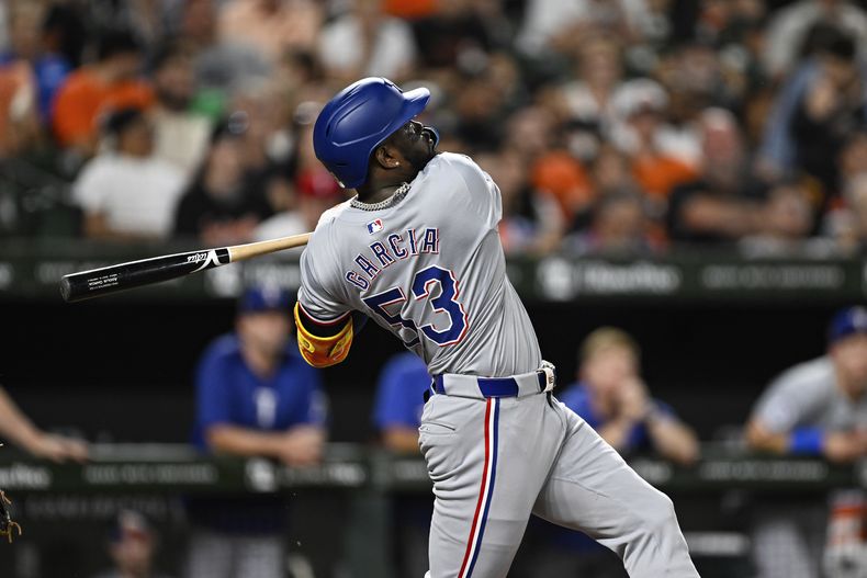 El cubano Adolis García, de los Rangers de Texas, batea un jonrón en el juego del sábado 29 de junio de 2024, ante los Orioles de Baltimore (AP Foto/Terrance Williams)