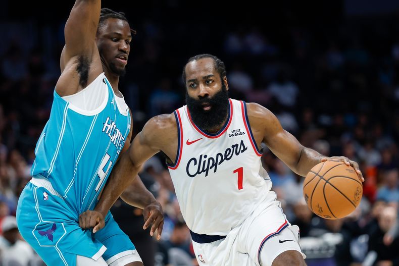 El base de los Clippers de Los Ángeles James Harden avanza hacia la canasta con el balón frente al base de los Hornets de Charlotte Sion James el sábado 22 de noviembre del 2025. (AP Foto/Nell Redmond)