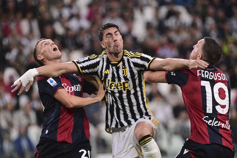 El delantero de la Juventus Dusan Vlahovic (centro) pugna por el balón frente a jugadores de Bologna en la Serie A, el domingo 27 de agosto de 2023. (Marco Alpozzi/LaPresse vía AP)