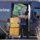 Una persona que entrega mercancía de Amazon Prime acomoda paquetes al hacer una parada en un edificio de apartamentos, el martes 28 de noviembre de 2023, en Denver. (AP Foto/David Zalubowski)