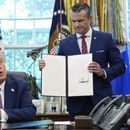 El presidente de EEUU, Donald Trump, habla mientras el secretario de Defensa, Pete Hegseth, sostiene una orden ejecutiva firmada en el Despacho Oval de la Casa Blanca, en Washington, el viernes 5 de septiembre de 2025. (AP Foto/Alex Brandon)