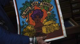 Sara Vega, especialista de la Cinemateca cubana, muestra un poster promocional sobre el arte del tabaco durante una entrevista en la Cinemateca en La Habana, el martes 11 de julio de 2023. El listado de Memoria del Mundo de la UNESCO ahora incluye una colección de seis décadas de carteles impresos en serigrafía de películas cubanas. (AP Foto/Ramón Espinosa)