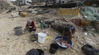 ARCHIVOS- Palestinos se bañan y lavan sus herramientas en agua salada debido a la escasez de agua en la Franja de Gaza, en la playa de Deir al-Balah, Franja de Gaza, 29 de octubre de 2023. (AP Foto/Mohammed Dahman, File)