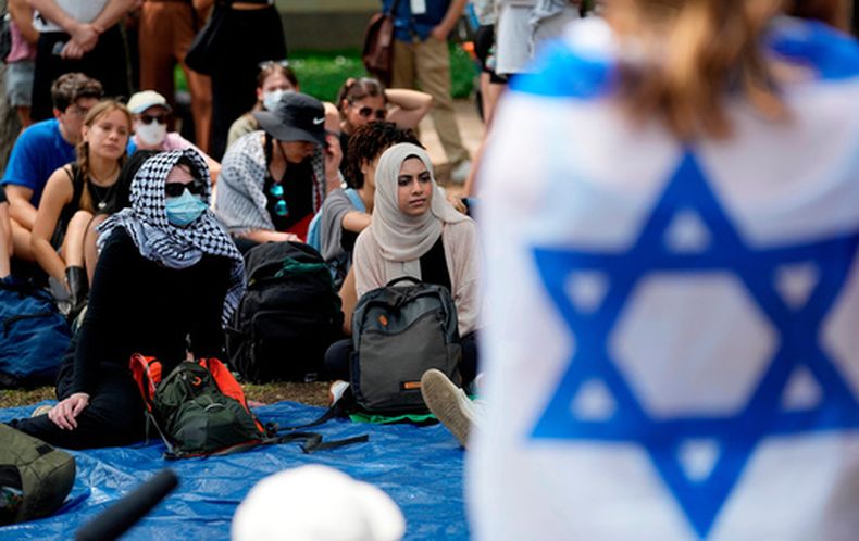Una estudiante arropada con una bandera israelí escucha a manifestantes propalestinos en la Universidad de Texas en Austin, el 30 de abril del 2024. (AP foto/Eric Gay)