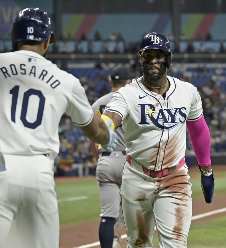 El dominicano de los Rays de Tampa Bay Amed Rosario felicita a su compañero Yandy Diaz después de que anotó ante el abridor de los Yankees de Nueva York el martes 9 de julio del 2024.. (AP Foto/Steve Nesius)