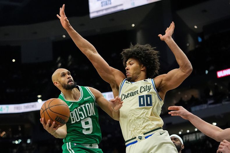 Derrick White (9), de los Celtics de Boston, busca encestar ante la marca defensiva de Jericho Sims (00), de los Bucks de Milwaukee, durante la segunda mitad del juego de baloncesto de la NBA, el lunes 2 de marzo de 2026, en Milwaukee. (AP Foto/Aaron Gash)