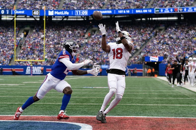 El receptor abierto de los Cardinals de Arizona, Marvin Harrison Jr. (18), realiza un atrapada de touchdown ante el esquinero de los Giants de Nueva York, Deonte Banks (2), durante un partido de fútbol americano de la NFL en East Rutherford, Nueva Jersey, el domingo 4 de octubre de 2026. (Foto AP/Seth Wenig)