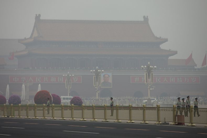 Polic&iacute;as paramilitares patrullan la plaza de Tiananmen en un d&iacute;a de alta contaminaci&oacute;n en Beijing, China, el 2 de junio de 2013. Las autoridades de China anunciaron el mi&eacute;rcoles la creaci&oacute;n de un fondo para recomenzar a