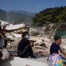 Residentes se sientan cerca de sus casas destruidas dos días después del sismo que azotó La Guaira, Venezuela, el viernes 26 de junio de 2026. (Foto AP/Ariana Cubillos)
