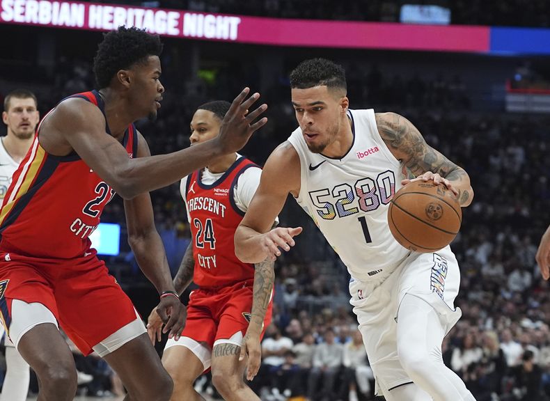 Michael Porter Jr., derecha, de los Nuggets de Denver, lleva el balón rumbo a la canasta mientras Yves Missi, de los Pelicans de Nueva Orleans, defiende durante la primera mitad del juego de baloncesto de la NBA, el miércoles 5 de febrero de 2025, en Denver. (AP Foto/David Zalubowski)
