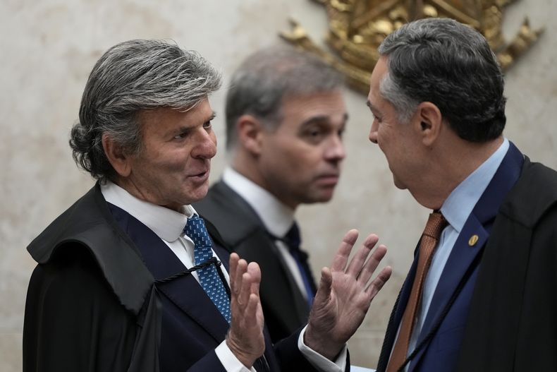 El ministro Luiz Fux, a la izquierda, representante de Google en Brasil, habla con el juez del Supremo Tribunal Federal Roberto Barroso, el miércoles 4 de junio de 2025, en Brasilia. (AP Foto/Eraldo Peres)