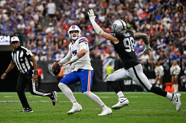 Josh Allen (17), de los Bills de Buffalo, se alista a lanzar un pase bajo la presión de Maxx Crosby (98), de los Raiders de Las Vegas, durante el partido de la NFL del domingo 18 de octubre de 2026, en Las Vegas. (AP Foto/David Becker)