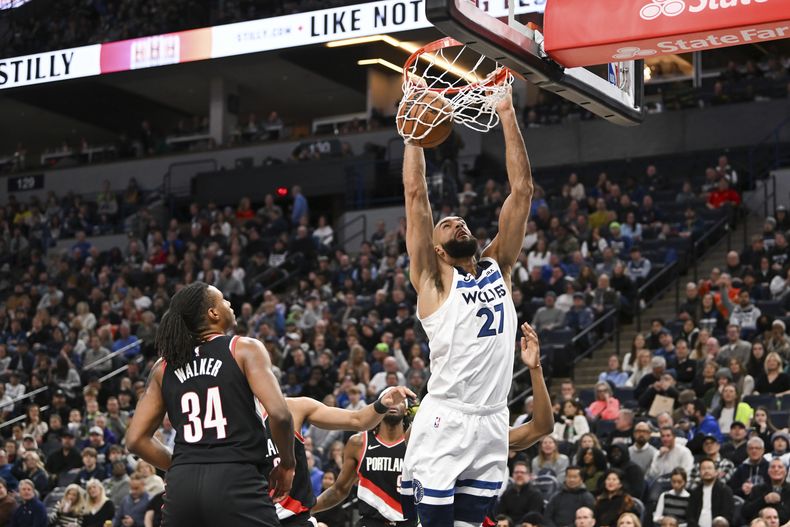 El pívot francés Rudy Gobert de los Timberwolves de Minnesota realiza una volcada frente a Jabari Walker, de los Trail Blazers de Portland, el viernes 12 de enero de 2024 (AP Foto/Craig Lassig)
