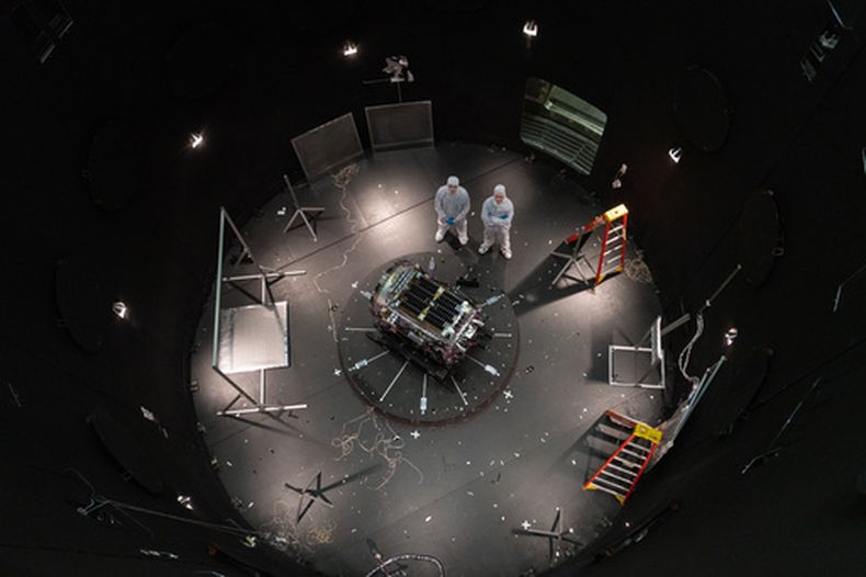Foto entregada por la NASA que muestra a Kieran Wilson, investigador principal de LINK, y Hunter Robertson, ingeniero de sistemas espaciales, al lado de su nave espacial dentro del Simulador de Ambiente Espacial en el Centro Goddard de la NASA en Greenbelt, Maryland, el 17 de abril del 2026. (Sophia Roberts/NASA via AP)