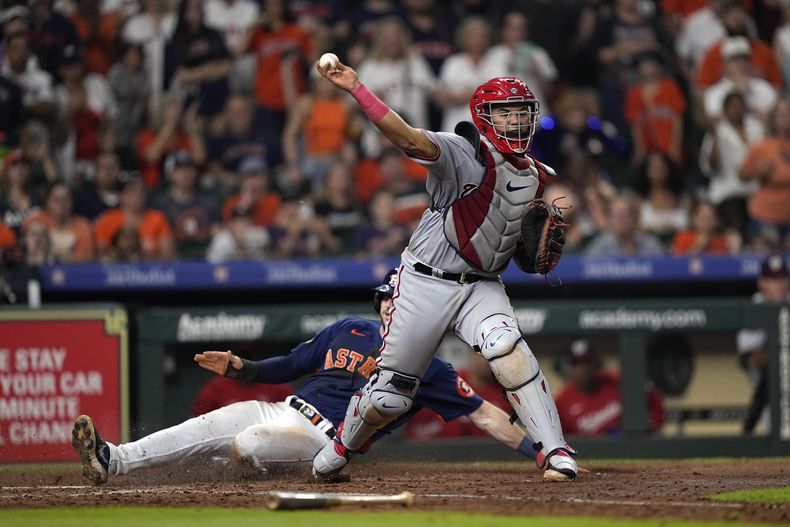 El receptor Keibert Ruiz, de los Nacionales de Washington, lanza a primera después de forzar un out en el plato al jardinero derecho Kyle Tucker, durante la novena entrada del juego de béisbol el miércoles 14 de junio de 2023, en Houston. A Ruiz le marcaron error en el tiro, que permitió que el primera base de los Astros José Abreu anotara la carrera de la victoria. Los Astros ganaron 5-4. (AP Foto/David J. Phillip)