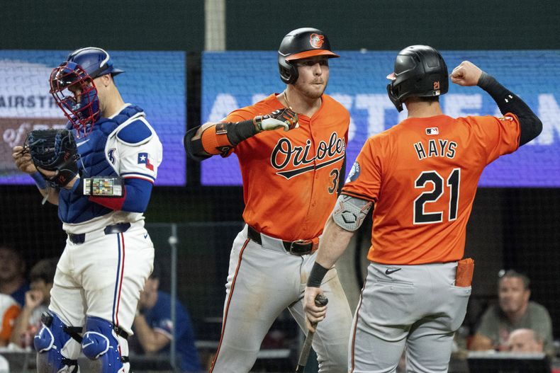 Ryan OHearn, de los Orioles de Baltimore, a la izquierda, es felicitado por Austin Hays (21) después de conectar un jonrón solitario ante el lanzador relevista de los Rangers de Texas, José Leclerc, durante la novena entrada el sábado 20 de julio de 2024, en Arlington, Texas. (AP Foto/Jeffrey McWhorter)