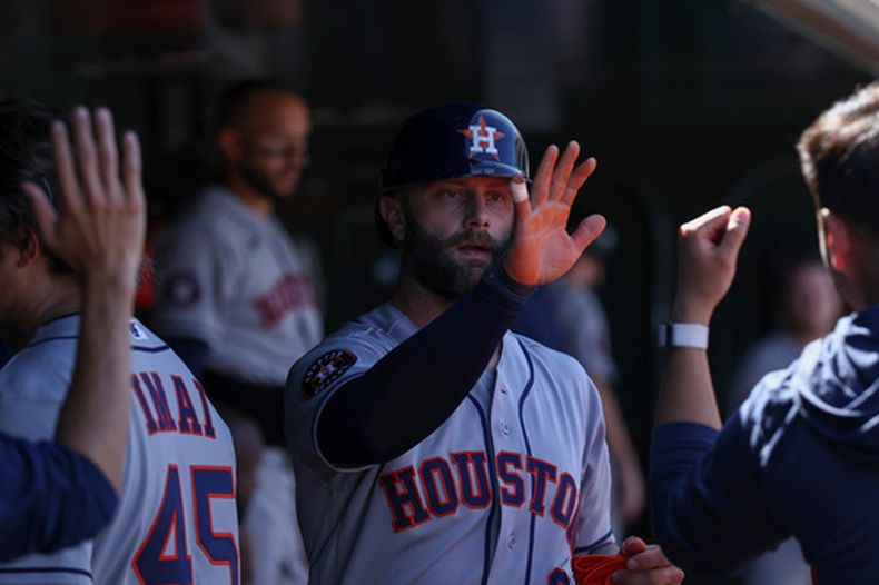Christian Walker, de los Astros de Houston, es felicitado en la cueva luego de anotar ante los Atléticos, el sábado 4 de abril de 2026 en West Sacramento (AP Foto/Sara Nevis)