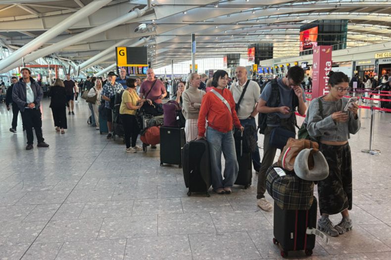 Pasajeros esperan en fila en el aeropuerto de Heathrow en Londres durante un problema con el tránsito aéreo que alteró los desplazamientos en Reino Unido. (Jonathan Brady/PA vía AP)