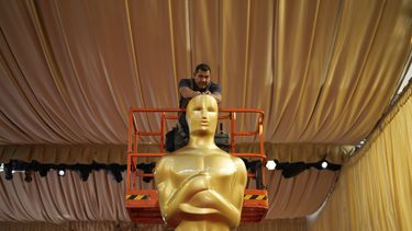 Un trabajador ayuda a colocar una estatua de los Oscar en la alfombra roja previo a la 96a entrega de los Premios de la Academia el sábado 9 de marzo de 2024, en Los Angeles. (Foto AP/John Locher)