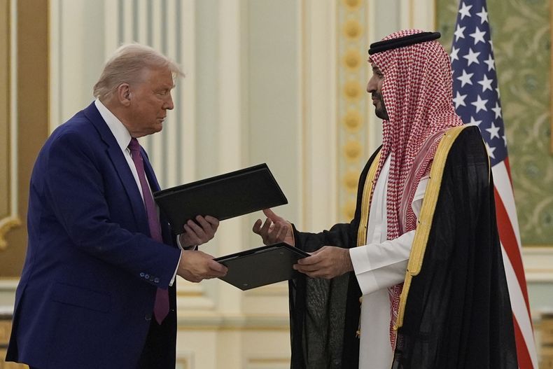 El presidente estadounidense Donald Trump y el príncipe saudí Mohammed bin Salman intercambian documentos en el Palacio Real en Riad, Arabia Saudí, el 13 de mayo del 2025. (AP Photo/Alex Brandon)