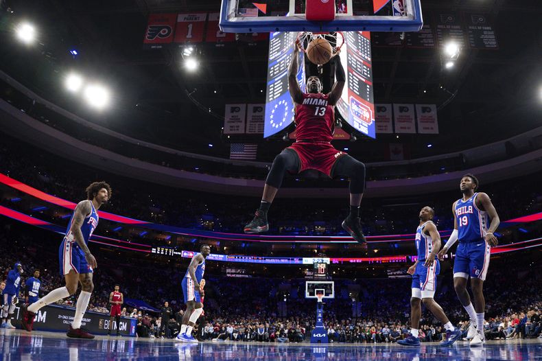 Bam Adebayo, centro, del Heat de Miami, clava el balón mientras los integrantes de los 76ers de Filadelfia observan durante la segunda mitad del juego de baloncesto de la NBA, el miércoles 5 de febrero de 2025, en Filadelfia. El Heat ganó 108-101. (AP Foto/Chris Szagola)