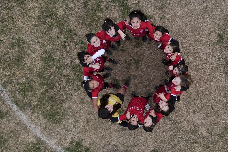 En foto del 19 de junio del 2023, jugadoras del Huracán femenino posan para una foto antes del encuentro ante el Alumni in Arequito en Argentina. (AP Foto/Natacha Pisarenko)
