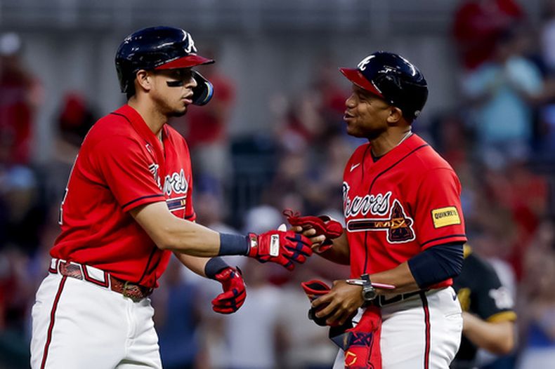 El hondureño Mauricio Dubón (izquierda), de los Bravos de Atlanta, festeja con el coach de primera Antoan Richardson luego de pegar un doble productor ante los Piratas de Pittsburgh, el viernes 5 de junio de 2026 (AP Foto/Erik S. Lesser)