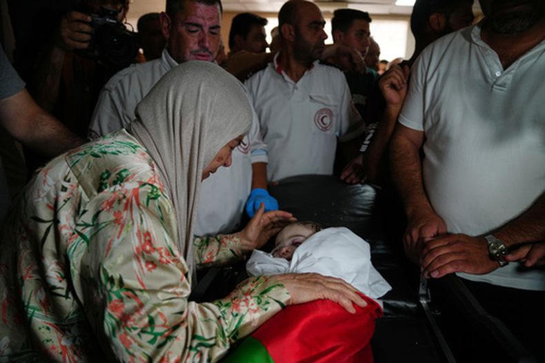 Feryal Abu Haikal, a la izquierda, da su último adiós a su nieto palestino de siete meses, Sam, quien, según el Ministerio de Salud palestino, murió el viernes cuando soldados israelíes dispararon contra el vehículo en que viajaban él y sus padres en Tel Rumeida, durante su funeral en la ciudad de Hebrón, en Cisjordania, el sábado 6 de junio de 2026. (Foto AP/Mahmoud Illean)