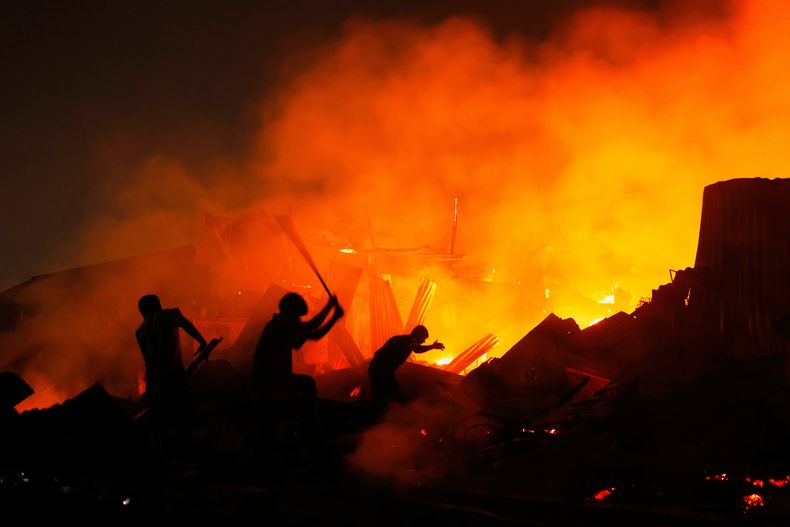 Rescatistas intentan apagar un gran incendio en la barriada Korail en Daca, Bangladesh, el martes 25 de noviembre de 2025. (AP Foto/Rajib Dhar)