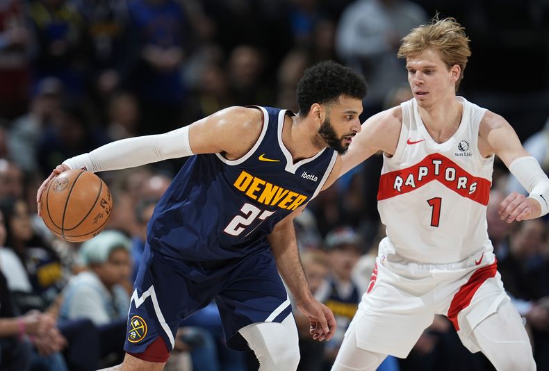 Jamal Murray, izquierda, de los Nuggets de Denver, ataca la canasta con la marcación defensiva de Gradey Dick, de los Raptors de Toronto, en la segunda mitad del juego de baloncesto de la NBA, el lunes 11 de marzo de 2024, en Denver. (AP Foto/David Zalubowski)