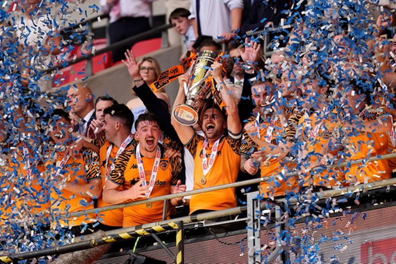 Lewis Coyle, del Hull City, levanta el trofeo tras lograr el ascenso a la Liga Premier luego de la final del play-off del Championship entre el Hull City y el Middlesbrough en el Estadio de Wembley, Londres, el sábado 23 de mayo de 2026. (Jordan Pettitt/PA vía AP)