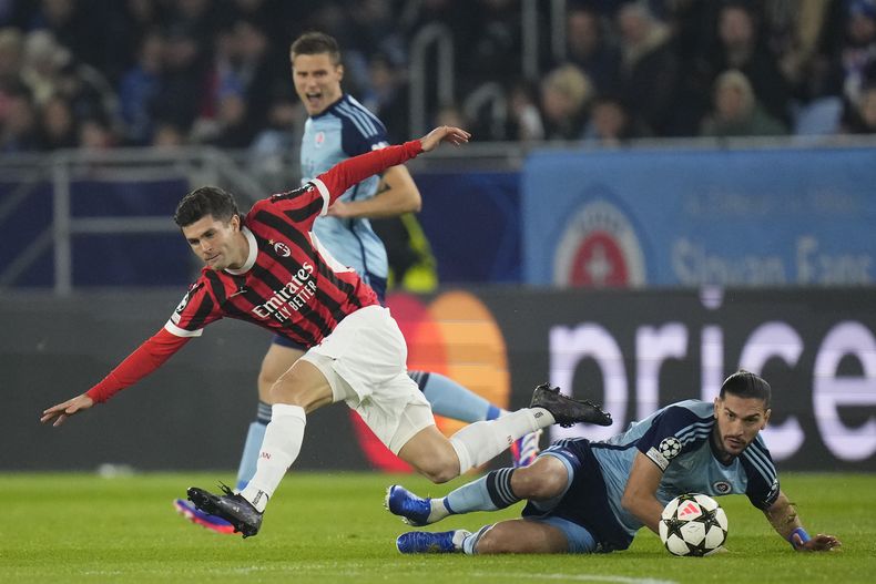 Christian Pulisic (izquierda) del AC Milan y el Kyriakos Savvidis del Slovan Bratislava pugnan por el balón en el partido de la Liga de Campeones, el martes 26 de noviembre de 2024. (AP Foto/Petr David Josek)