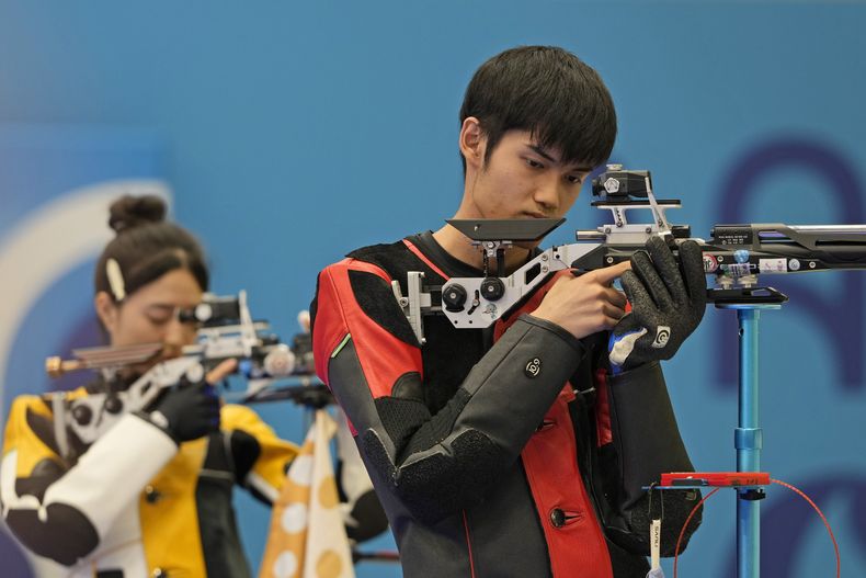 Los chinos Sheng Lihao (derecha) y Huang Yuting compiten por la medalla de oro de la prueba de equipos mixtos con carabina comprimida desde 10 metros en los Juegos Olímpicos, el sábado 27 de julio de 2024, en Chateauroux, Francia. (AP Foto/Manish Swarup)