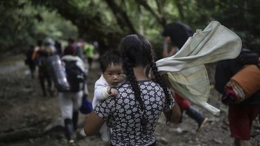 Una migrante boliviana carga un bebé mientras cruza el Tapón del Darién, de Colombia a Panamá, con la esperanza final de llegar a Estados Unidos, el 9 de mayo de 2023. (AP Foto/Iván Valencia)