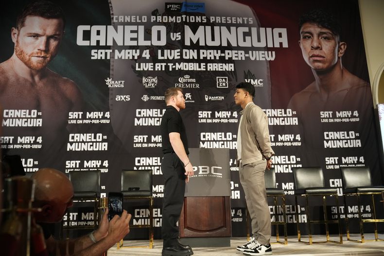 El campeón del peso medio Canelo Alvarez, posa con su rival del próximo 4 de mayo Jaime Munguía en la conferencia de prensa para promover la pelea el martes 19 de marz del 2024. (AP Foto/Damian Dovarganes)