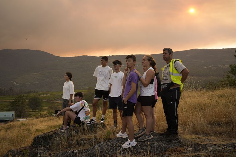 Un grupo de personas observan los incendios en A Cañiza, Pontevedra, España, el 30 de julio del 2025. (Adrián Irago/Europa Press via AP)