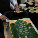 Un mesero corta trozos de un pastel decorado con la portada de la novela En agosto nos vemos para celebrar el cumpleaños del autor colombiano Gabriel García Márquez y el lanzamiento de su novela póstuma en una librería en la Ciudad de México el miércoles 6 de marzo de 2024. (Foto AP/Eduardo Verdugo)