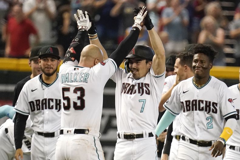 Corbin Carroll (7) es felicitado por Christian Walker luego de empujar dos carreras en la novena entrada del duelo del jueves 1 de junio de 2023, ante los Rockies de Colorado (AP Foto/Darryl Webb)