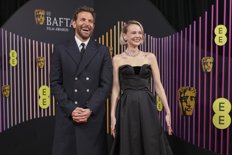 Bradley Cooper, izquierda, y Carey Mulligan posan a su llegada a la 77a entrega de los Premios de la Academia Británica de Cine (BAFTA) en Londres el domingo 18 de febrero de 2024. (Foto Vianney Le Caer/Invision/AP)