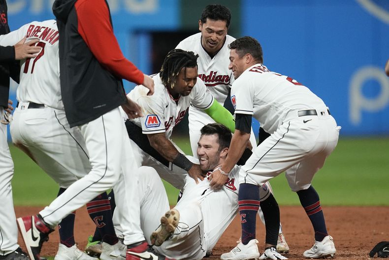David Fry es felicitado por sus compañeros de los Guardianes de Cleveland luego de remolcar la carrera de la victoria sobre los Orioles de Baltimore, el viernes 22 de septiembre de 2023 (AP Foto/Sue Ogrocki)