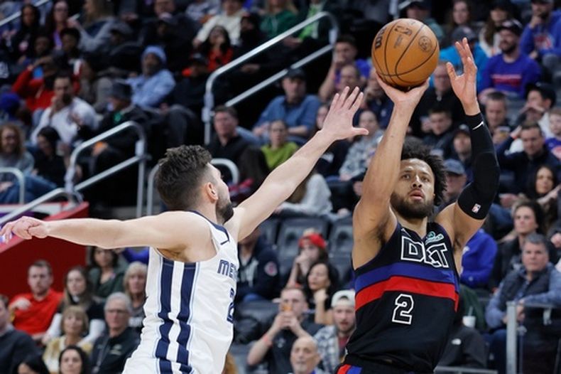 Cade Cunningham (2), de los Pistons de Detroit, dispara a la canasta ante la presión defensiva de Ty Jerome, izquierda, de los Grizzlies de Memphis, durante la segunda mitad del juego de baloncesto de la NBA, el viernes 13 de marzo de 2026, en Detroit. (AP Foto/Duane Burleson)