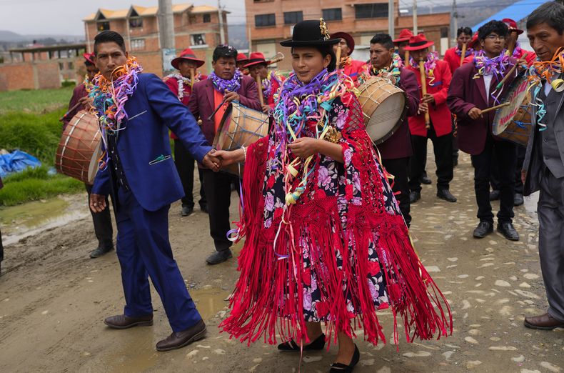 Parejas indígenas aymara bailan en el Martes de Challa, una celebración que forma parte del carnaval boliviano en que se hacen ofrendas a la Pachamama o Madre Tierra, en Achocalla, Bolivia, el martes 13 de febrero de 2024. (AP Foto/Juan Karita)