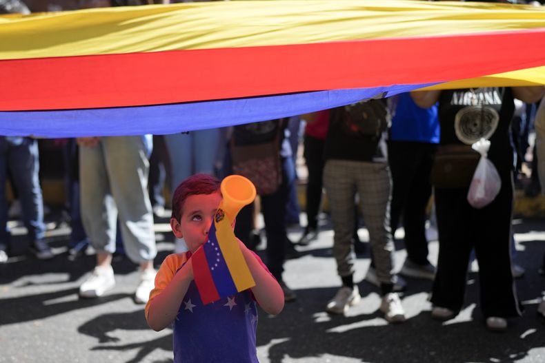 Un niño sopla una bocina durante una protesta de opositores del presidente venezolano Nicolás Maduro el día antes de su toma de posesión para un tercer mandato en Caracas, Venezuela, el jueves 9 de enero de 2025. (AP Foto/Matías Delacroix)