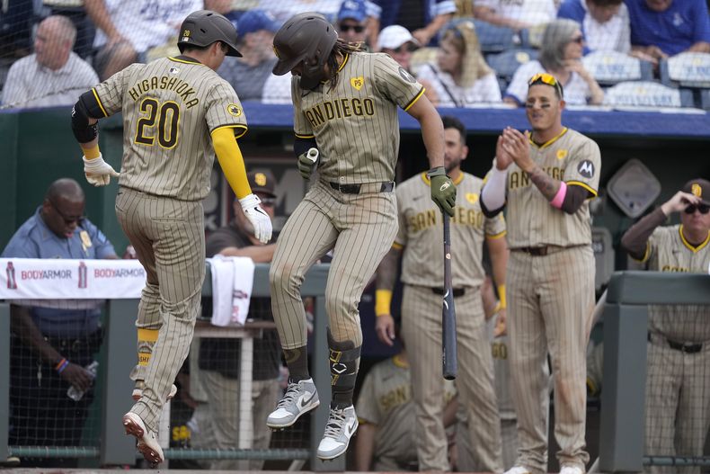 Kyle Higashioka (20), de los Padres de San Diego, celebra con Fernando Tatis Jr. después de conectar un jonrón solitario durante la novena entrada de un juego de béisbol contra los Reales de Kansas City, el sábado 1 de junio de 2024, en Kansas City, Missouri. Los Padres ganaron 7-3. (AP Foto/Charlie Riedel)